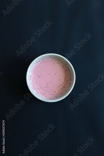 pink matcha latte in a large cup on the leather sofa of the cafe's outdoor terrace hard sunlight. High quality photo