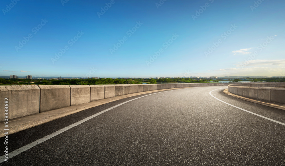 Fototapeta premium Low angle curvy flyover highway moving forward road with nature blue sky scape morning scene view.