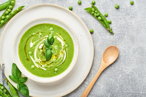 Green peas soup. Healthy vegan green peas soup served in bowl on rustic table.