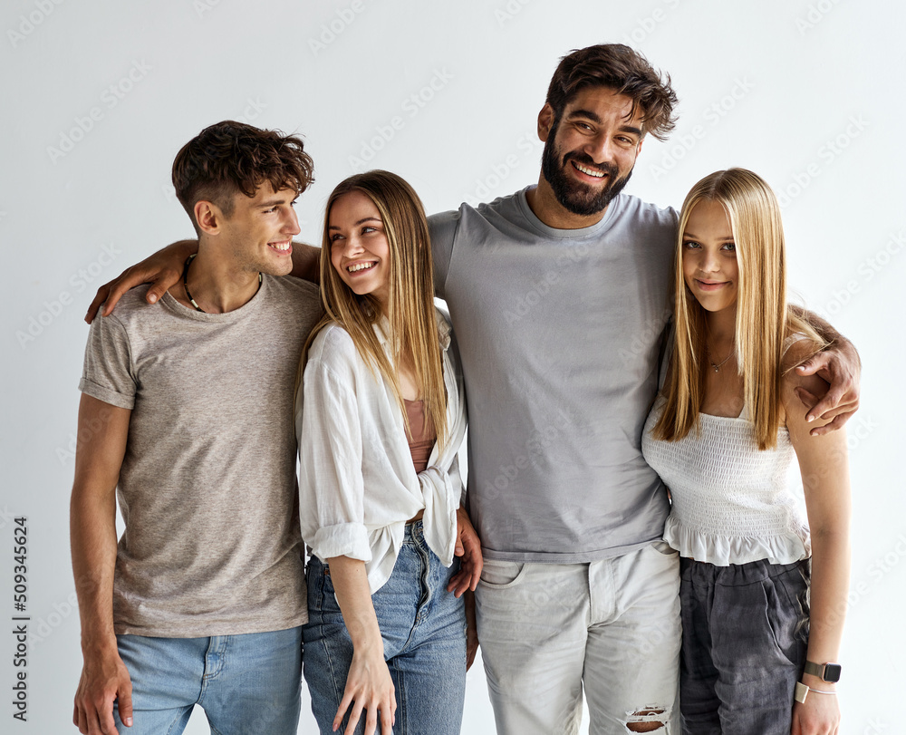 Group of happy friends hugging and looking at the camera