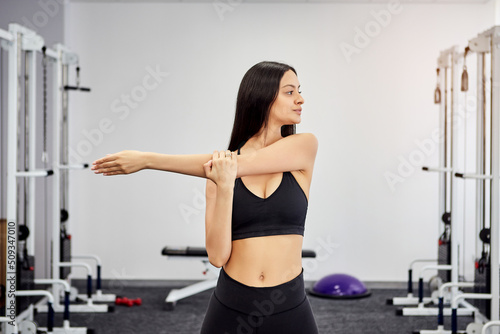 Female patient trains in rehabilitation kinesio clinic and does a warm-up