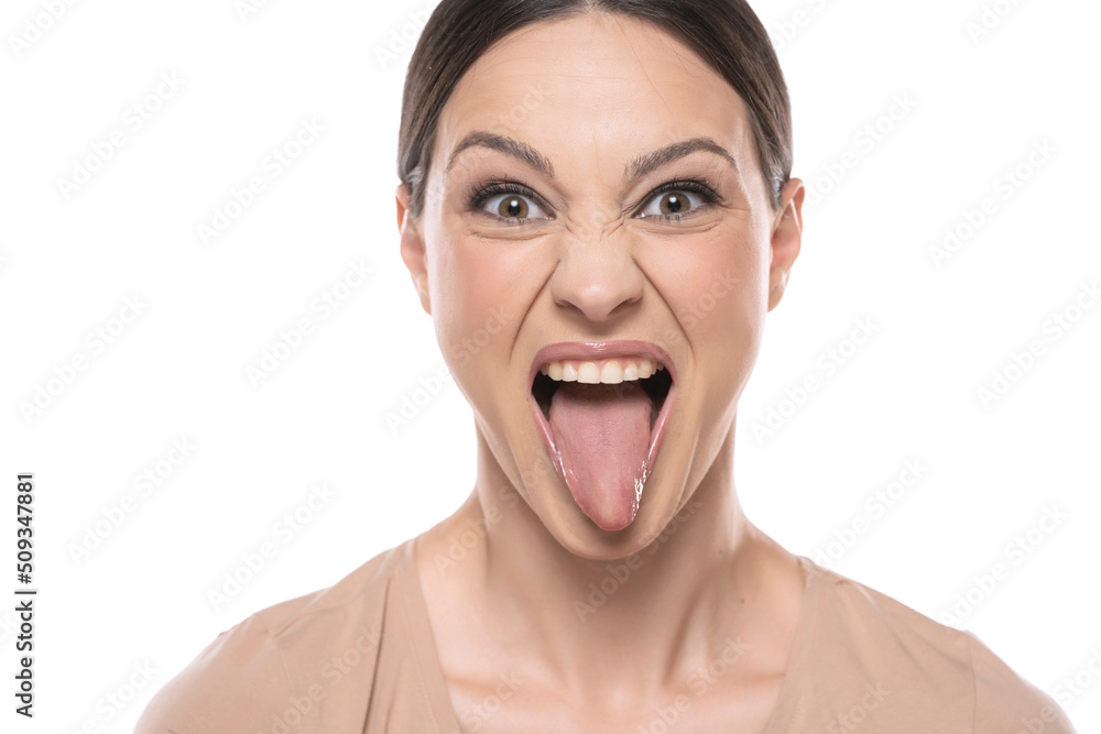 Woman with funny face mocking someone sticking her tongue out Woman with funny face mocking someone sticking her tongue out