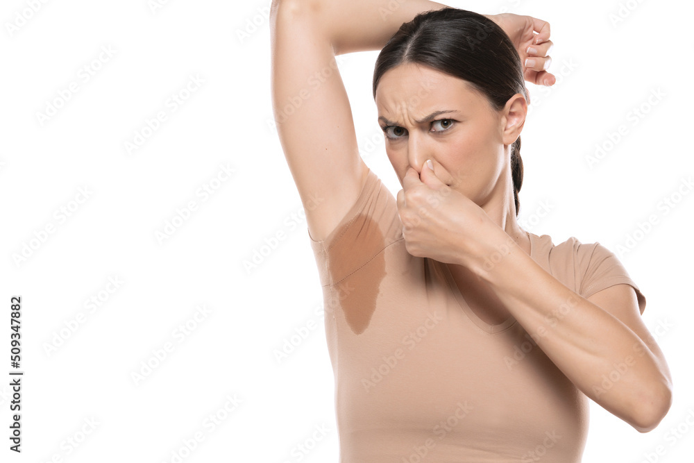 Young woman hand squeezing nose with odor sweating,Female smelling or sniffing her armpit,Bad smell Young woman hand squeezing nose with odor sweating,Female smelling or sniffing her armpit,Bad smell