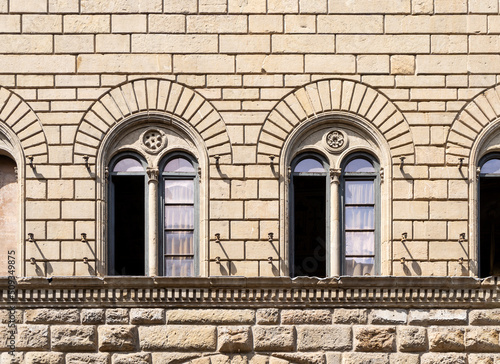Detail of the façade of Medici Riccardi palace designed by Renaissance architect Michelozzo with two mullioned windows, in Florence city center, Tuscany region, Italy photo
