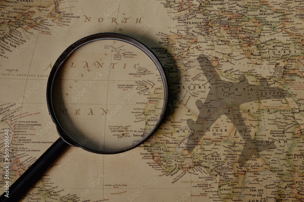 Magnifying glass on world travel map with airplane Magnifying glass on world travel map with airplane