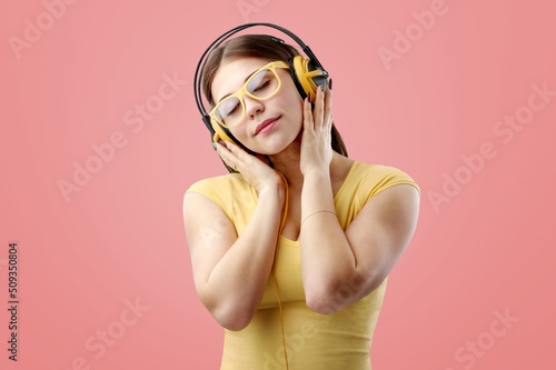 Happy lady with headphones listening to music and dancing, cool playlist and moving concept.