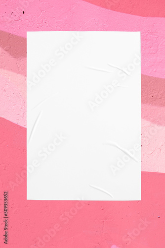 Closeup of colorful pink coral beige painted urban wall texture with wrinkled glued poster template. Modern mockup for design presentation. Creative urban city background. 
