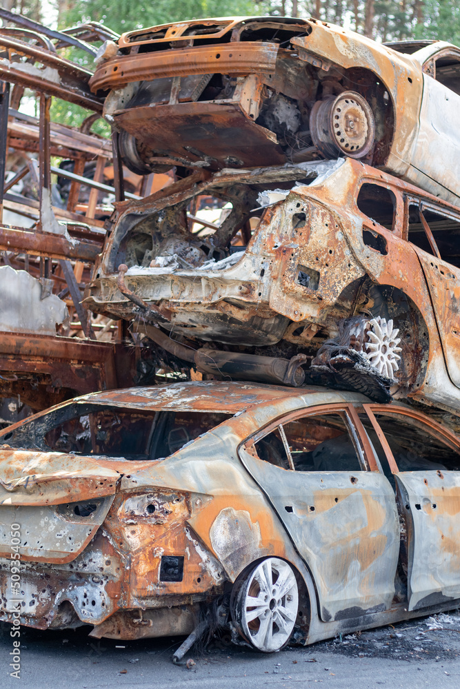 A lot of rusty burnt cars in Irpen, after being shot by the Russian military. Russia's war against Ukraine. Cemetery of destroyed cars of civilians who tried to evacuate from the war zone.