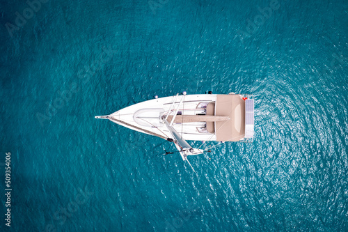 Sailing boat at blue sea from above (aerial drone photo)
