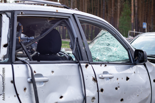 Car riddled with bullets. War of Russia against Ukraine. A car of civilians shot by the Russian military during the evacuation of women and children. Traces of bullets and fragments of shells. © Yevhen Roshchyn
