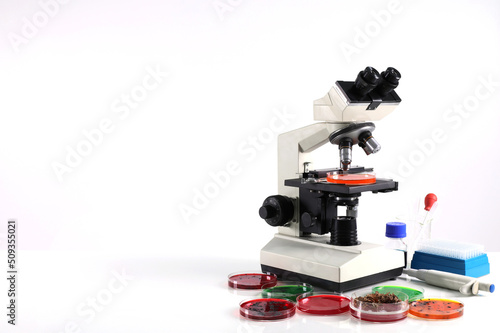 Microscope on the table with chemical tube and glassware in laboratory, Science research technology on the table and white background