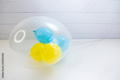 yellow and blue balloons in a transparent balloon