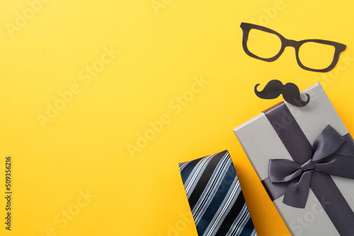 Father's day gift design concept with gift box and necktie on yellow background.