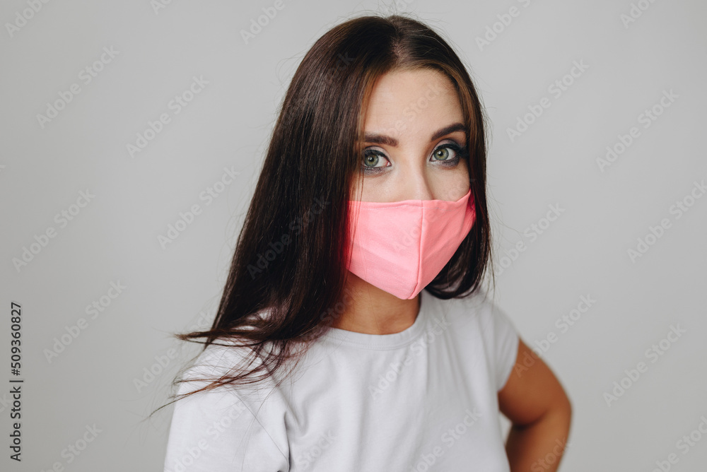 Closeup Portrait of Brunette Girl in Mask on Background of White Wall in Daylight Closeup Portrait of Brunette Girl in Mask on Background of White Wall in Daylight