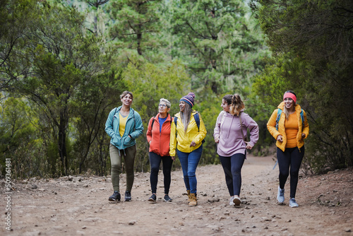 Multiethnic women having fun during hiking day in the mountain forest