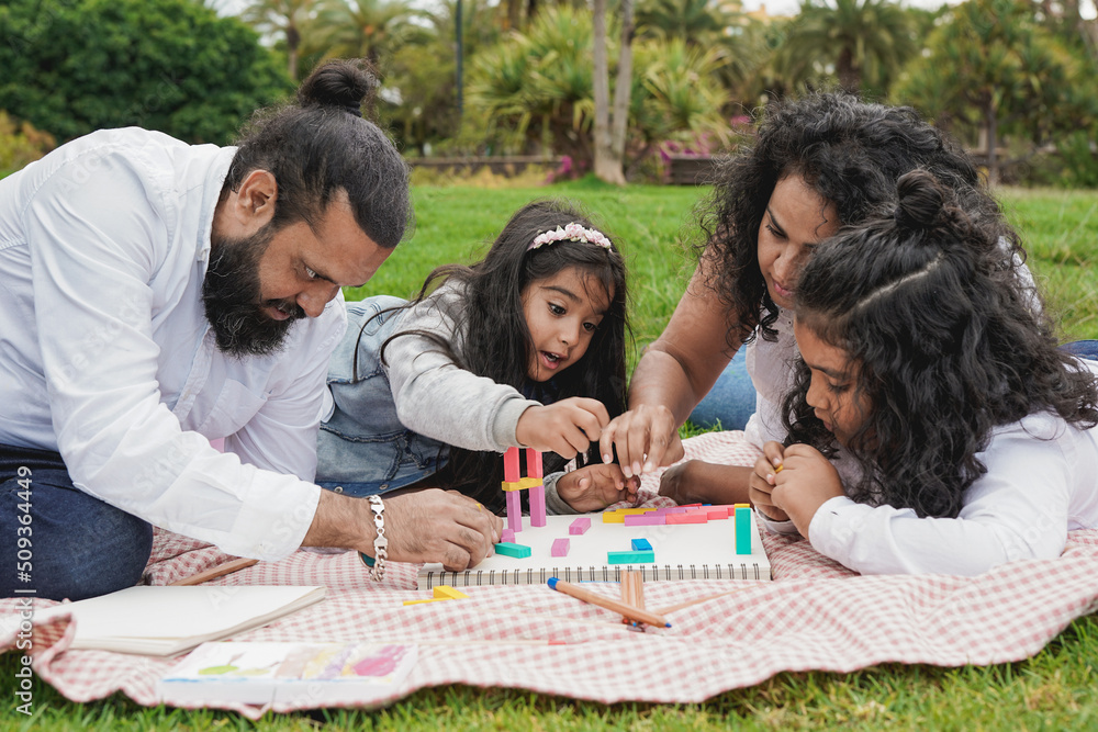 happy indian family enjoy day together at city park - Hindu parents having playful time with children outdoor happy indian family enjoy day together at city park - Hindu parents having playful time with children outdoor