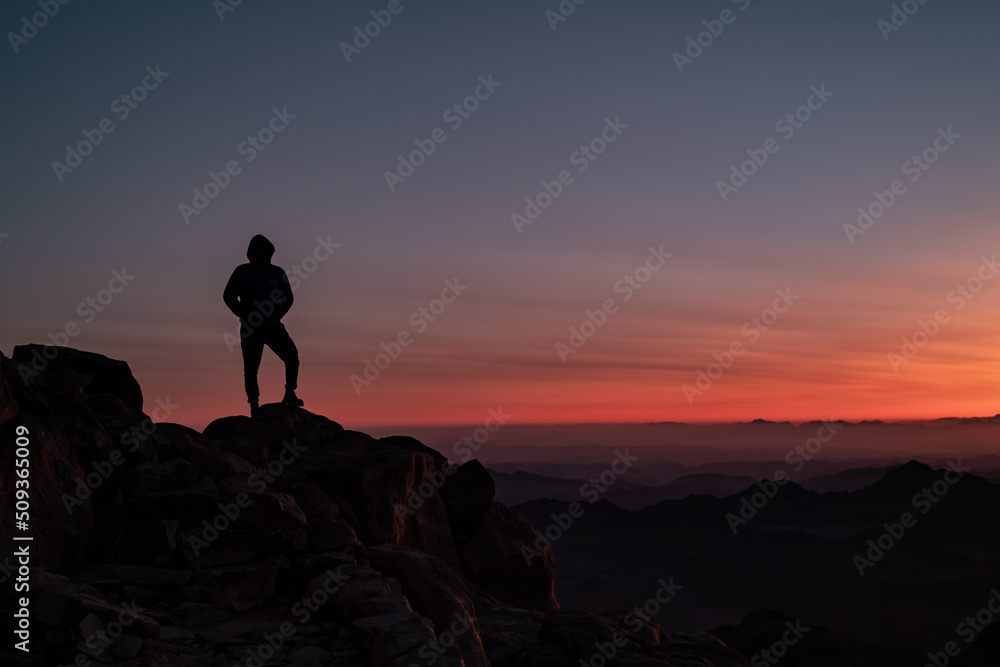 silhouette of a person on a mountain top during sunrise 