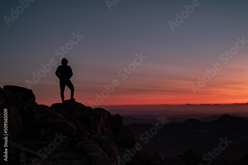 silhouette of a person on a mountain top during sunrise 