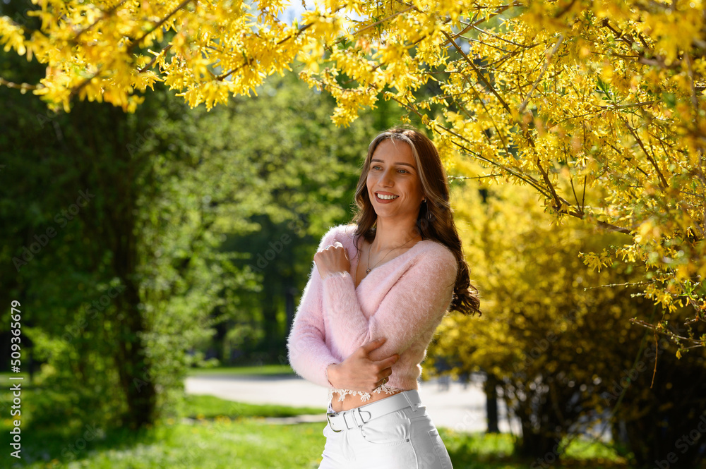 Beautiful young woman near blossoming shrub on spring day, space for text