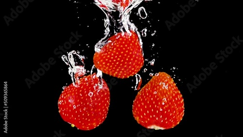 Super slow motion, fresh ripe strawberries fall into the water with air bubbles on a black background. Filmed on a high-speed cinema camera at 1000 fps. Stduio Shot, High quality Full HD footage. photo