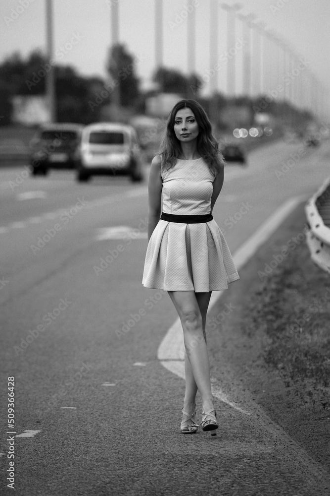 Beautiful slim woman in dress at the road in black and white Beautiful slim woman in dress at the road in black and white