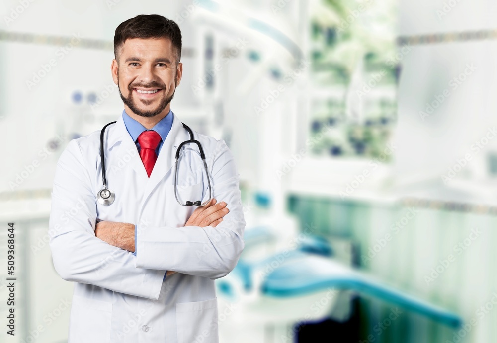 Dental doctor. Smiling Middle Dentist Doctor Stomatologist Standing With Folded Arms In Clinic Interior Dental doctor. Smiling Middle Dentist Doctor Stomatologist Standing With Folded Arms In Clinic Interior