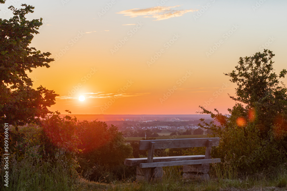 A beautiful sunset late Spring over the rolling hills from south Limburg. The wooden bench is an idyllic place for couples to enjoy a romantic evening overlooking to landscape.