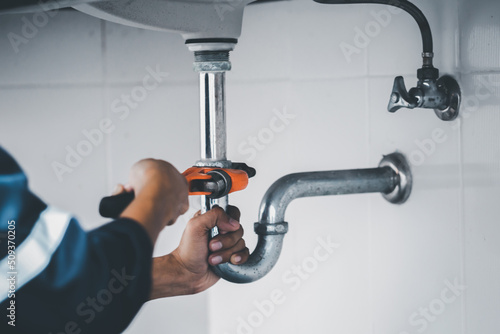 plumber at work in a bathroom, plumbing repair service, assemble and install concept. photo