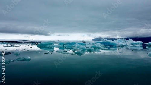 Gletscher Fjord und Gletscher Lagune. Kleine Eisstücke und riesige Eisberge - alles mit bewölktem Himmel.