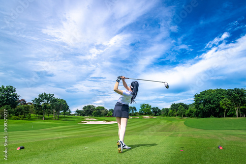 Professional woman golfer teeing golf in golf tournament competition at golf course for winner 