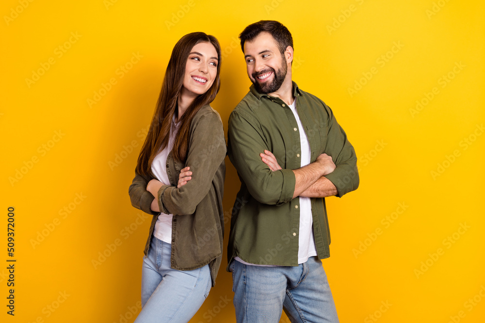 Portrait of attractive content cheerful couple folded arms dream team isolated over bright yellow color background Portrait of attractive content cheerful couple folded arms dream team isolated over bright yellow color background