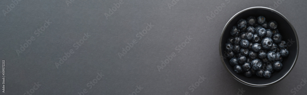 Top view of fresh blueberries in bowl on black surface, banner. Top view of fresh blueberries in bowl on black surface, banner.
