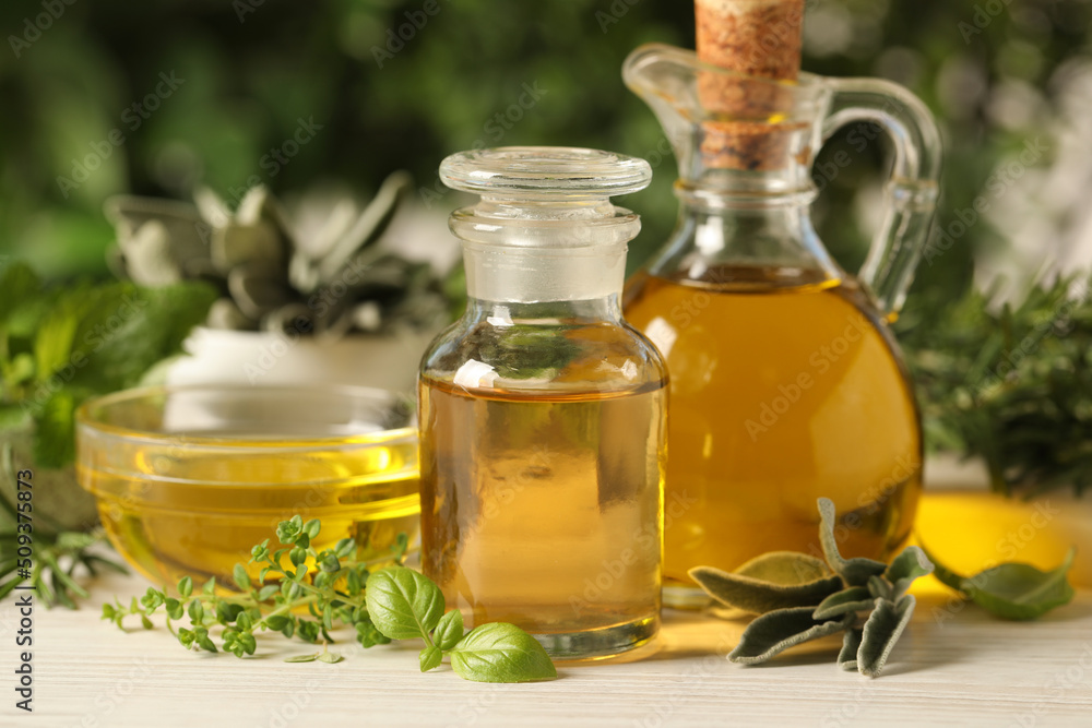 Different fresh herbs with oils on white wooden table, closeup Different fresh herbs with oils on white wooden table, closeup