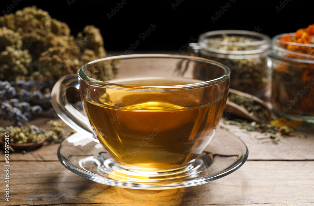 Freshly brewed tea and dried herbs on wooden table Freshly brewed tea and dried herbs on wooden table