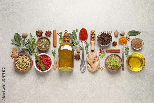 Different herbs and spices on grey table, flat lay