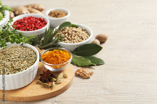 Different herbs and spices on wooden table. Space for text