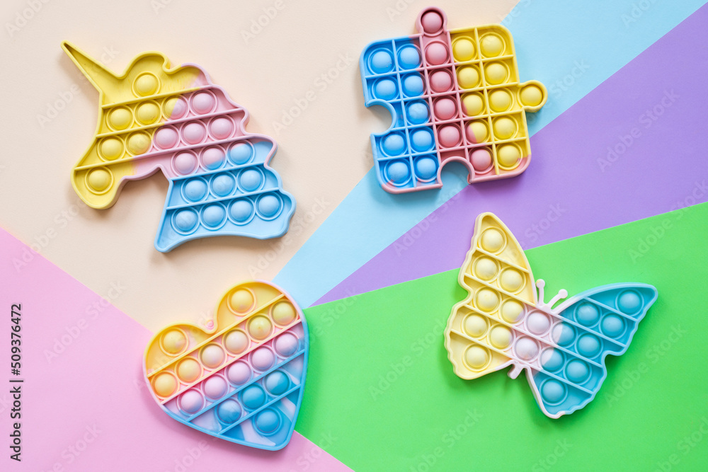 Rainbow pop it fidget toys on color background, flat lay. Rainbow pop it fidget toys on color background, flat lay.