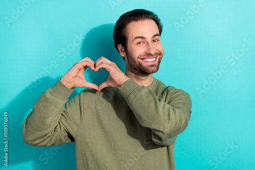 Photo of cool brunet young guy hands heart wear khaki sweatshirt isolated on teal color background