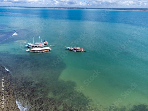 Schooner boat tour on the coral reef in the middle of the sea, Porto Seguro, Bahia, Brazil - natural beauty aerial drone view   