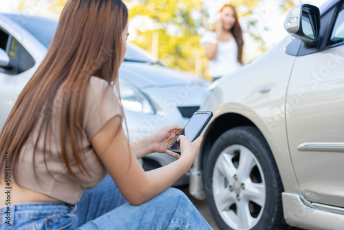 Two drivers check for damage after a car accident before taking pictures and sending insurance. Online car accident insurance claim idea after submitting photos and evidence to an insurance company. © Prot