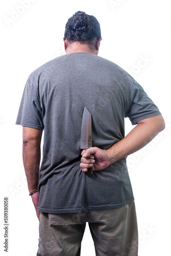 man holding knife behind his back. a man with a knife. Fototapeta