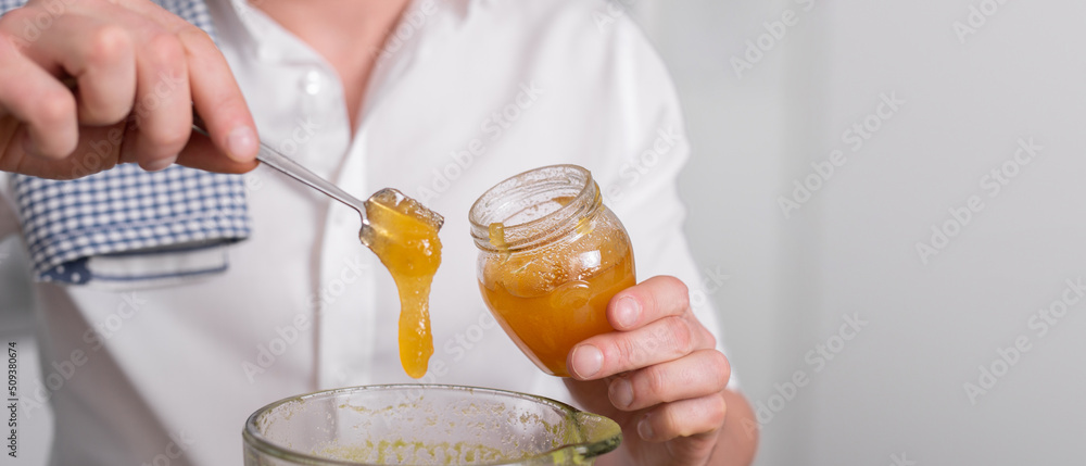 Close up cropped shot of man making smoothie and adding organic honey to blender or food processor. Close up cropped shot of man making smoothie and adding organic honey to blender or food processor.