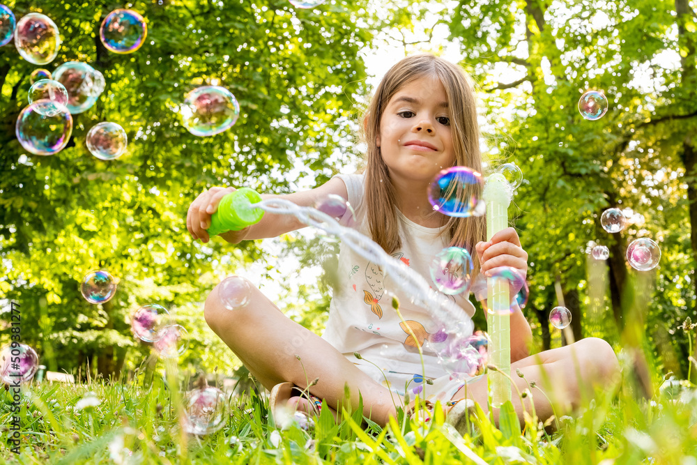 Une enfant qui joue à faire des bulles de savon dans un parc Stock Photo Adobe Stock