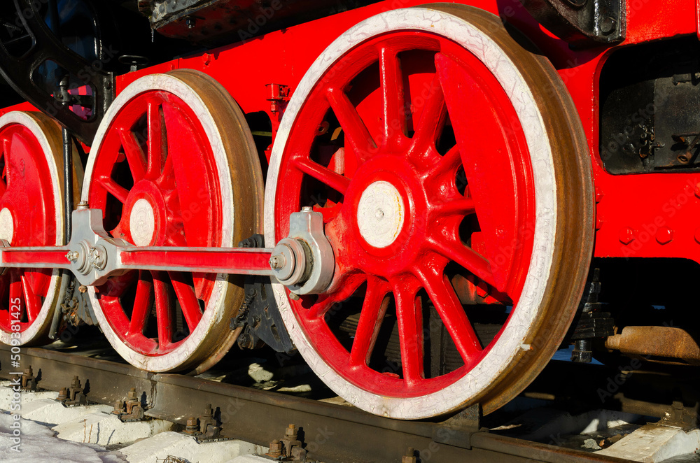 large red metal wheels with a white rim of an old steam locomotive with a movement mechanism large red metal wheels with a white rim of an old steam locomotive with a movement mechanism