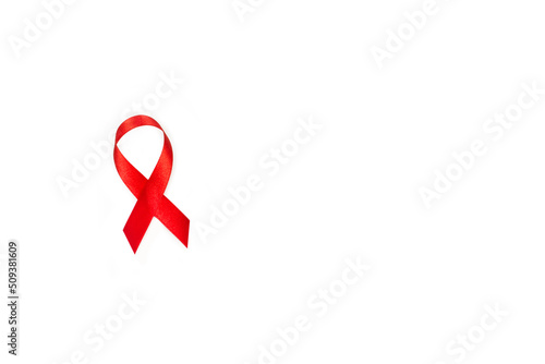 Lazo cinta roja de concienciación sobre el SIDA sobre un fondo blanco liso y aislado. Vista superior y de cerca. Copy space photo
