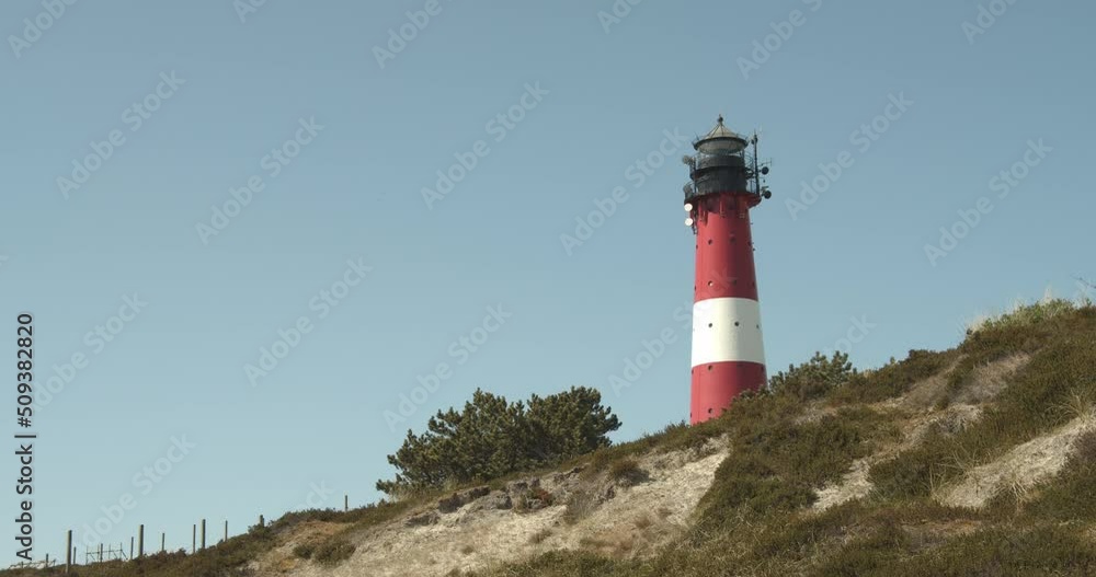 Lighthouse of Hörnum on Sylt with a dune in the foreground on a sunny day 4k 60fps Lighthouse of Hörnum on Sylt with a dune in the foreground on a sunny day 4k 60fps