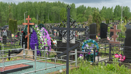 City cemetery with fresh graves, wooden and stone gravestones, metal crosses. City geaveyard.