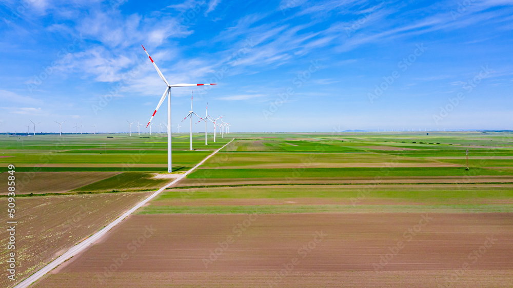 View on several windmills, wind generators, turbines, producing renewable clean energy by converting kinetic energy View on several windmills, wind generators, turbines, producing renewable clean energy by converting kinetic energy