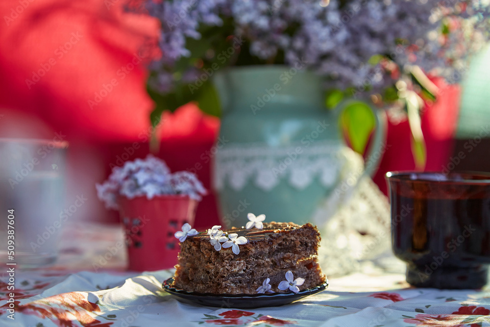 Homemade chocolate cake brownie. Dessert and cup of coffee among flowers. Atmospheric breakfast