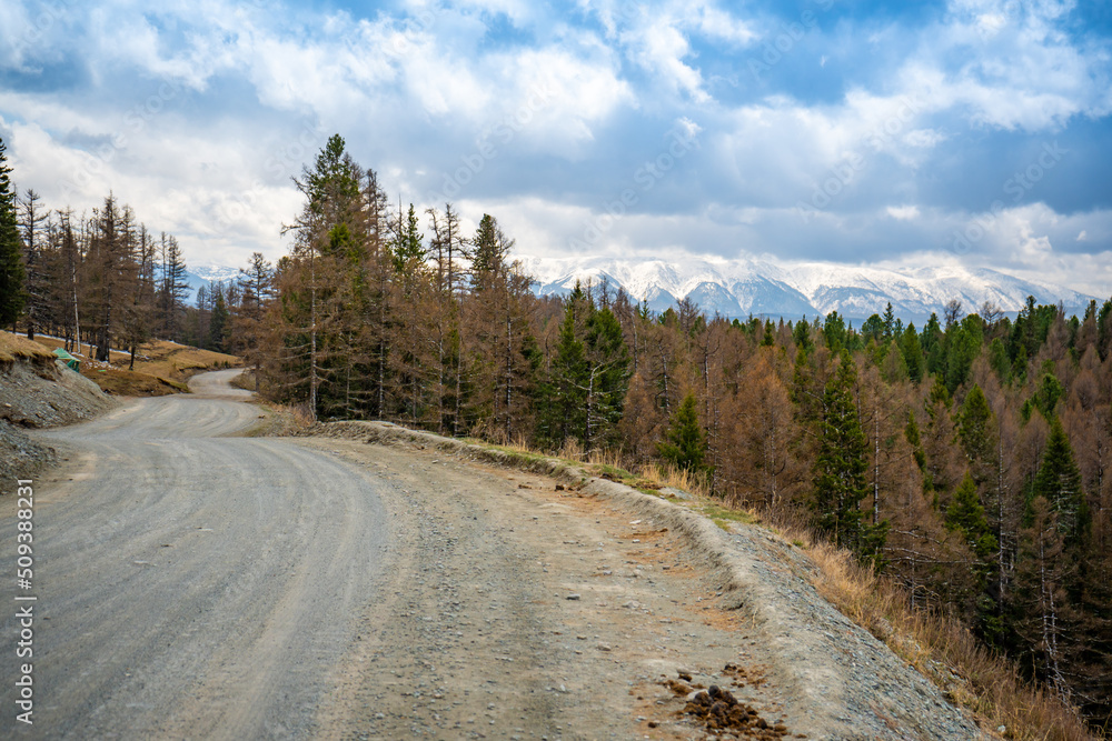 Road on the background of beautiful mountains in spring forest, Altai, Russia Road on the background of beautiful mountains in spring forest, Altai, Russia